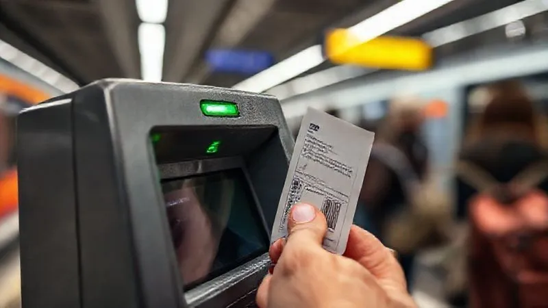 photorealistic, professional photography, 8K, cinematic lighting, sharp focus, depth of field, shot on a high-end DSLR. A close-up shot of a hand inserting a paper public transport ticket into a small validation machine at a train station entrance. The machine has a green light indicating success, with blurred commuters in the background, emphasizing a crucial, often overlooked step in city travel. photorealistic, professional photography, 8K, cinematic lighting, sharp focus, depth of field, shot on a high-end DSLR. A close-up shot of a hand inserting a paper public transport ticket into a small validation machine at a train station entrance. The machine has a green light indicating success, with blurred commuters in the background, emphasizing a crucial, often overlooked step in city travel.