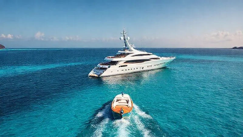 A photorealistic, professional photography, 8K, cinematic lighting, sharp focus, depth of field, shot on a high-end DSLR image of a luxurious private yacht anchored in a secluded, turquoise bay, with a tender boat heading towards a pristine, empty beach, conveying ultimate privacy and bespoke experience.