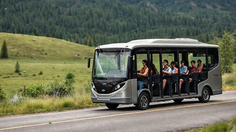 A photorealistic, professional photography, 8K, cinematic lighting, sharp focus, depth of field, shot on a high-end DSLR, of a sleek, modern, eco-friendly electric shuttle bus moving smoothly along a paved road within a national park. The bus is full of diverse, smiling passengers looking out at the beautiful natural scenery. The surrounding landscape is lush and well-maintained, with minimal signs of human impact. A photorealistic, professional photography, 8K, cinematic lighting, sharp focus, depth of field, shot on a high-end DSLR, of a sleek, modern, eco-friendly electric shuttle bus moving smoothly along a paved road within a national park. The bus is full of diverse, smiling passengers looking out at the beautiful natural scenery. The surrounding landscape is lush and well-maintained, with minimal signs of human impact.