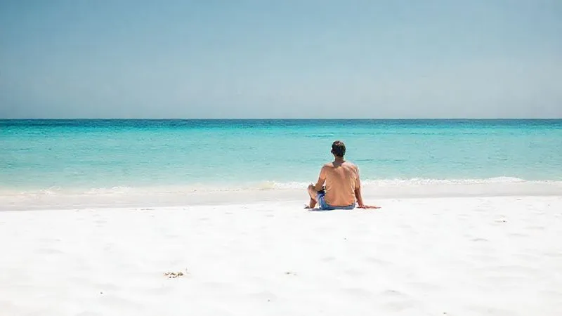 A photorealistic shot of a lone figure sitting peacefully on a genuinely secluded, dazzling white sand beach, gazing out at the calm, crystal-clear turquoise ocean. The beach is pristine, with no other people or signs of development. The atmosphere is one of profound serenity and solitude. 8K, professional photography, cinematic lighting, sharp focus on the figure and the foreground, depth of field blurring the distant horizon. A photorealistic shot of a lone figure sitting peacefully on a genuinely secluded, dazzling white sand beach, gazing out at the calm, crystal-clear turquoise ocean. The beach is pristine, with no other people or signs of development. The atmosphere is one of profound serenity and solitude. 8K, professional photography, cinematic lighting, sharp focus on the figure and the foreground, depth of field blurring the distant horizon.