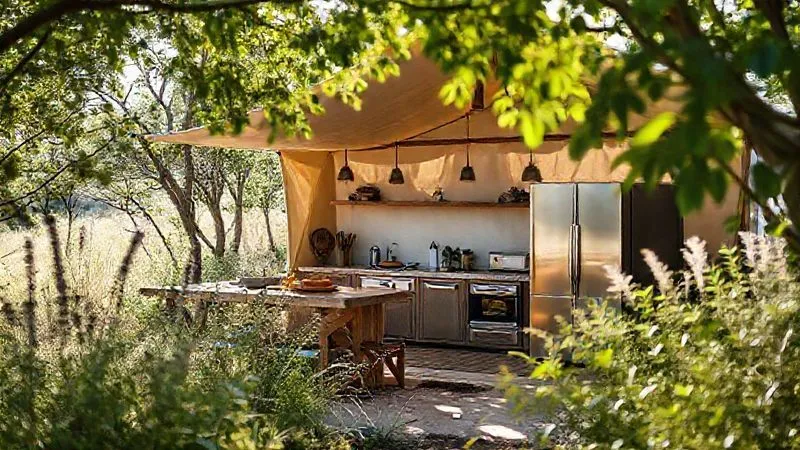 A photorealistic, professional photography, 8K, cinematic lighting, sharp focus, depth of field, shot on a high-end DSLR image of a perfectly sited luxury glamping outdoor kitchen. The kitchen is integrated into a natural landscape, perhaps with a slight elevation, surrounded by strategic planting that acts as a natural windbreak. Sunlight dapples through overhead foliage, suggesting thoughtful shade planning. The scene conveys harmony between luxury design and natural resilience. A photorealistic, professional photography, 8K, cinematic lighting, sharp focus, depth of field, shot on a high-end DSLR image of a perfectly sited luxury glamping outdoor kitchen. The kitchen is integrated into a natural landscape, perhaps with a slight elevation, surrounded by strategic planting that acts as a natural windbreak. Sunlight dapples through overhead foliage, suggesting thoughtful shade planning. The scene conveys harmony between luxury design and natural resilience.