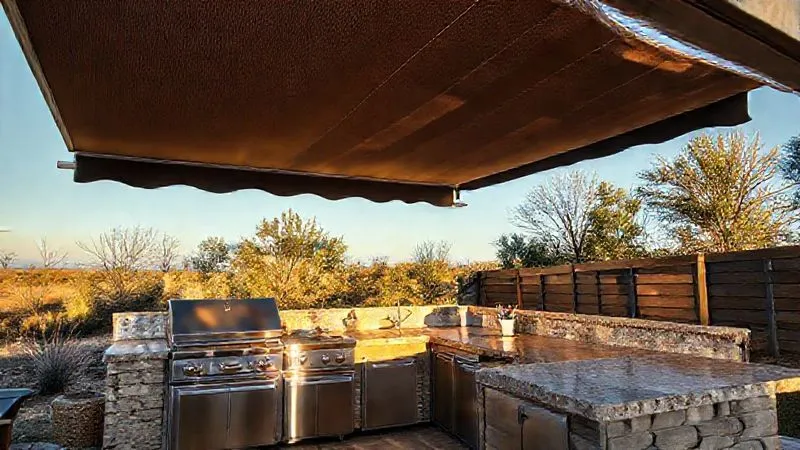 A photorealistic, professional photography, 8K, cinematic lighting, sharp focus, depth of field, shot on a high-end DSLR image of a luxurious glamping outdoor kitchen under a sleek, automated retractable awning. The awning is partially extended, casting a dynamic shadow pattern over the gleaming stainless steel appliances and natural stone countertops. The scene suggests sophisticated weather control and year-round usability. A photorealistic, professional photography, 8K, cinematic lighting, sharp focus, depth of field, shot on a high-end DSLR image of a luxurious glamping outdoor kitchen under a sleek, automated retractable awning. The awning is partially extended, casting a dynamic shadow pattern over the gleaming stainless steel appliances and natural stone countertops. The scene suggests sophisticated weather control and year-round usability.